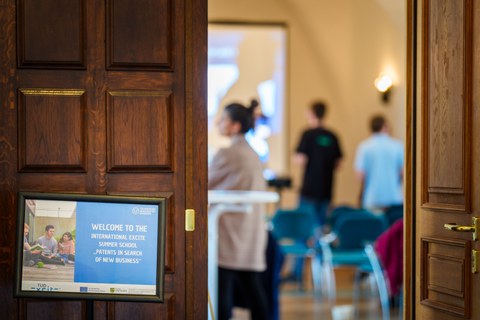 Display stand with logo, participants in the background