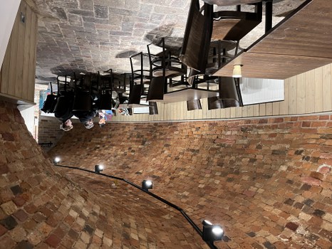 Row of tables and chairs, a group at the last one is discussing