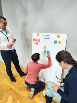 3 Teilnehmende arbeiten an einem Präsentationsboard