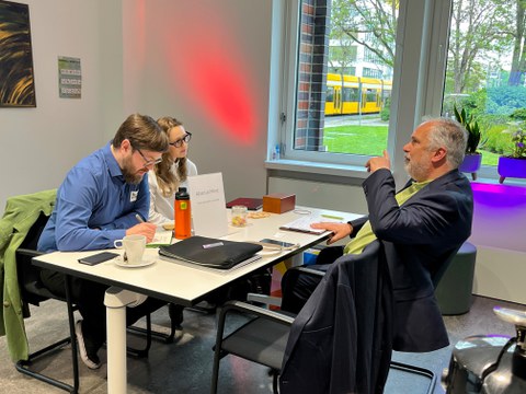 Three people are sitting at the table, discussing something