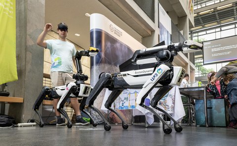 Foto einer Person mit den CeTI Robotern bei der Langen Nacht der Wissenschaft 2023.