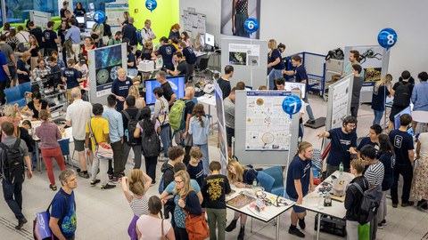 Foto vom Bereich mit nummerierten Informationsständen bei der Langen Nacht der Wissenschaft 2023.