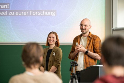 zwei Personen vor einem Auditorium