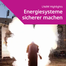 Person in Schutzkleidung vor einer großen weißen Rauchwolke im Freien mit Text 'LNdW Highlights Energiesysteme sicherer machen'