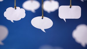 Photo of white speech bubbles of different shapes on a blue background