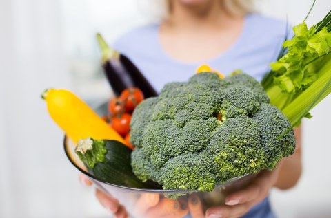 Das Foto zeigt eine Schale mit Gemüse, die von einer Frau gehalten wird.