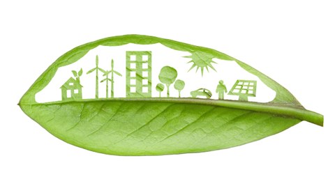 Foto von einem grünen Blatt auf dem eine Stadt mit erneuerbaren Energien gezeigt wird.