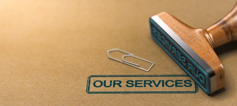 Stempel mit dem Text "Our Services" auf braunem Papierhintergrund