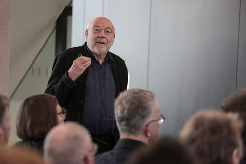 Impression aus der Veranstaltung. Vortragender vor Leinwand mit Präsentation zum Thema Farbe