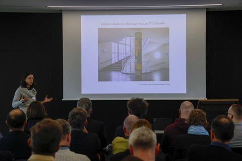 Impression aus der Veranstaltung. Vortragende vor Leinwand mit Präsentation zum Thema Farbe