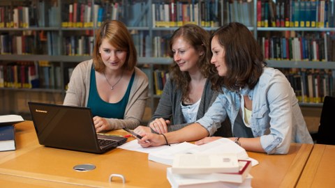 drei Doktorandinnen arbeiten in der Bibliothek