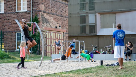 Foto von Personen, die beim TU-Was-Pfad der TU Dresden Sport machen. 