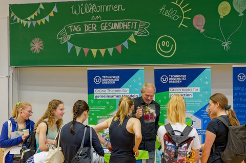 Studierende vor Stand des Umweltmanagements beim Gesundheitsmarkt am Tag der Gesundheit