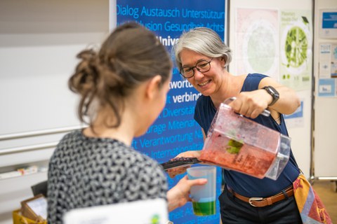 Eine Person die einer anderen eine Smoothie einschänkt