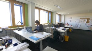 Mitarbeiterinnen und Mitarbeiter von Quabis sitzen in ihrem Büro und arbeiten.