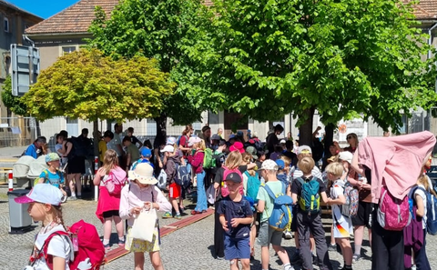 Sommerlich gekleidete Kinder laufen über den Marktplatz bei den Zukunfstagen Hirschfelde