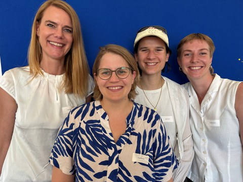 Vier Menschen vor blauem Hintergrund