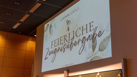 Darstellung des Textes Feierliche Zeugnisübergabe mit Beamer an der Wand.