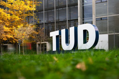 Foto von großen Buchstaben TUD auf der Wiese am HSZ im Herbst