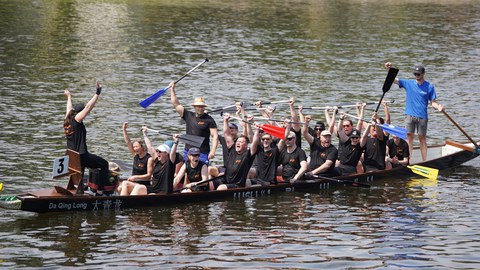 Drachenbootteam sitzt stolz im Boot und freut sich über ihren Sieg.
