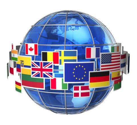 Das Foto zeigt die Darstellung eines Globus. Um den Globus herum schweben die Flaggen verschiedener Länder. Auch die europäische Flagge ist zu erkennen.