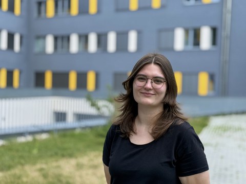 Lauras Rahm, eine junge Frau mit dunklen Haaren und Brille, schaut freundlich in die Kamera.