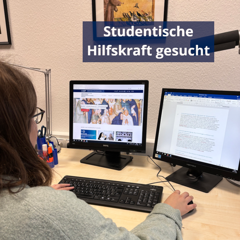 Eine Frau sitzt am Schreibtisch, wir schauen über ihre rechte Schulter. Die eine Hand liegt auf der Tastatur, die andere auf der Maus. Vor ihr stehen zwei Monitore. Auf dem linken Monitor ist die Webseite der FOVOG zu sehen, rechts ein Word-Dokument.