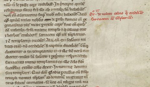 Ein Ausschnitt einer mittelalterlichen Handschrift auf Pergament. Auf der linken Seite befindet sich ein in lateinischer Sprache verfasster Textabschnitt, der in einer dichten, historischen Minuskelschrift mit schwarzer Tinte geschrieben ist. Rechts daneben steht eine kurze, zweizeilige Randnotiz (Glosse) in roter Tinte. Das Pergament hat eine leicht gelbliche, gealterte Färbung mit minimalen Flecken auf der rechten Freifläche.