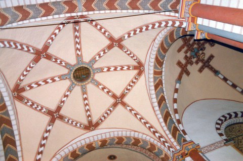 Das Bild zeigt das Kirchengewölbe der Joahnniterkirche, welches neben vielen Verzierungen ein Patriarchalkreuz erkennen lässt.