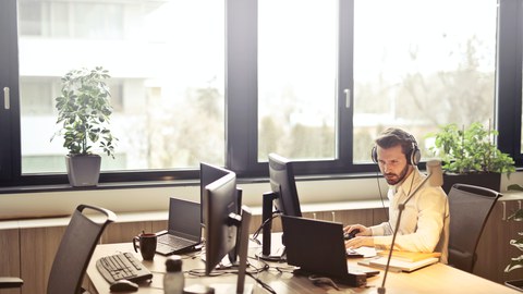 Mann vor Computer an Schreibtisch