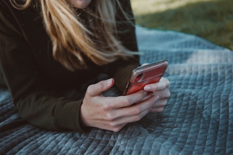 Eine Frau die auf ein Handy guckt