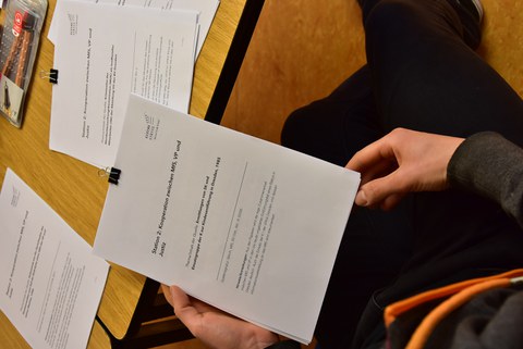 Das Foto zeigt im Fokus eine Fallakte des Spezialkommandos des MfS, sie wird von einer Person während des Lesens in den Händen gehalten.