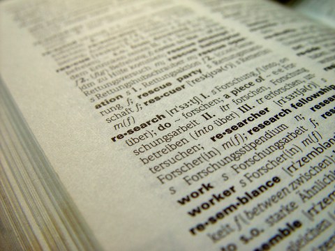 Zu sehen ist ein aufgeklapptes Wörterbuch, in dem der Artikel "research" sichtbar ist.