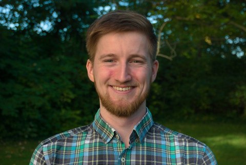 ein lächelnder Mann im Grünen