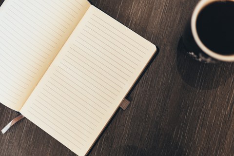 Notizbuch und Kaffee auf Tisch