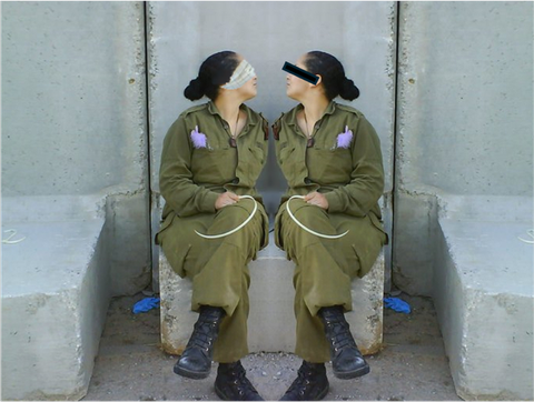 Two women sit facing each other on a concrete block. It is the same woman, the image is mirrored. She is wearing overalls, her hair is dark and tied back in a bun. There is a purple object in her breast pocket and she is holding a thin white object in her hand, reminiscent of a cable tie. Her eyes are blindfolded with a scarf (left) and a black strip covers her eyes (right). 