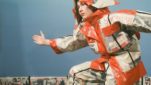 Monika Andres, Name, Stadt, Land (Zeitungskostüm und Transparent), 1988