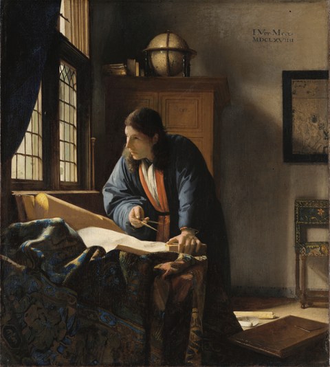 A man in a blue robe with an orange sash stands at a table with spread maps holding a compass, with a globe on a cabinet and a window with panes in the background.