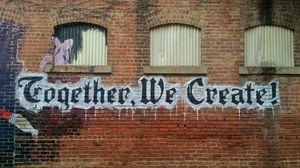 Logo "Together We Create" auf Hauswand