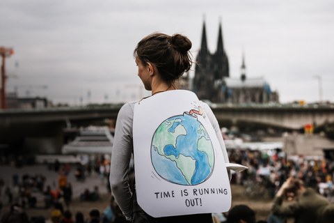 Junge Frau mit Demoplakat auf einer Klimademonstration in Kölln
