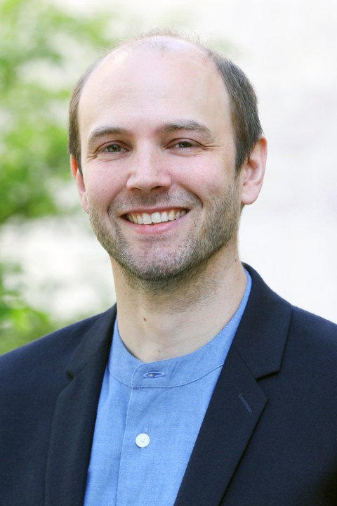 Portrait photo of Dr. Johan Horst wearing a dark blue jacket and light blue shirt.