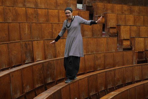 Anja Besand balanciert im Hörsaal auf den Tischen