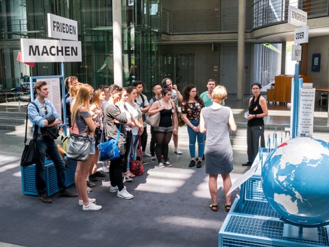 Eine Gruppe geht durch die Ausstellung Frieden Machen 