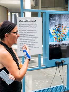 Eine Gruppe geht durch die Ausstellung Frieden Machen