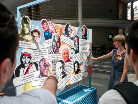 Eine Gruppe geht durch die Ausstellung Frieden Machen
