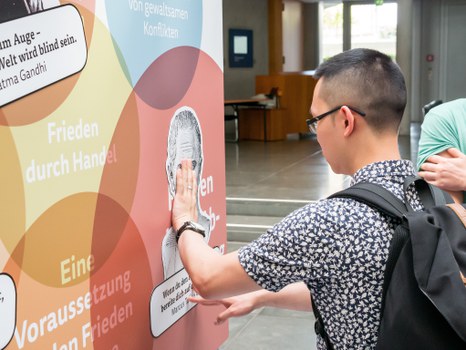 Eine Gruppe geht durch die Ausstellung Frieden Machen