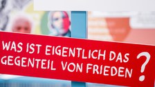 Eine Gruppe geht durch die Ausstellung Frieden Machen