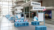 Eine Gruppe geht durch die Ausstellung Frieden Machen