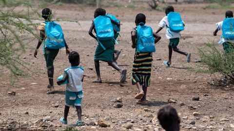 Kinder mit blauen Rucksaecken von UNICEF
