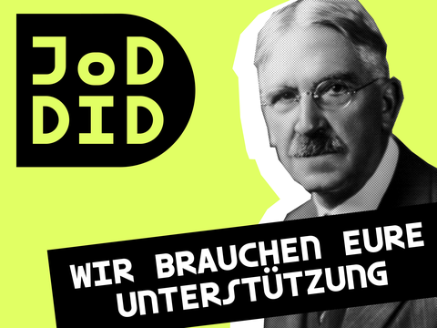 John Dewey mit Schild "Wir brauchen Unterstützung"